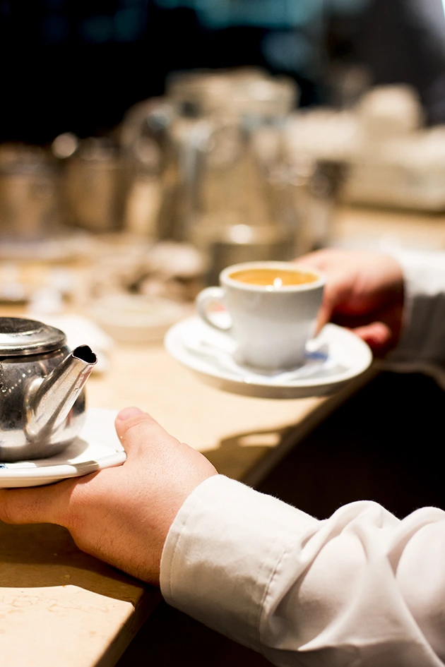 Barista preparando café de especialidad en barra de cafetería gestionada por BG Asesores